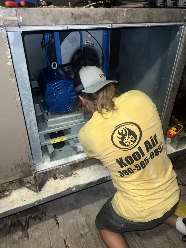 Kool Air technician servicing an indoor air handler during an AC repair in Palm Coast FL