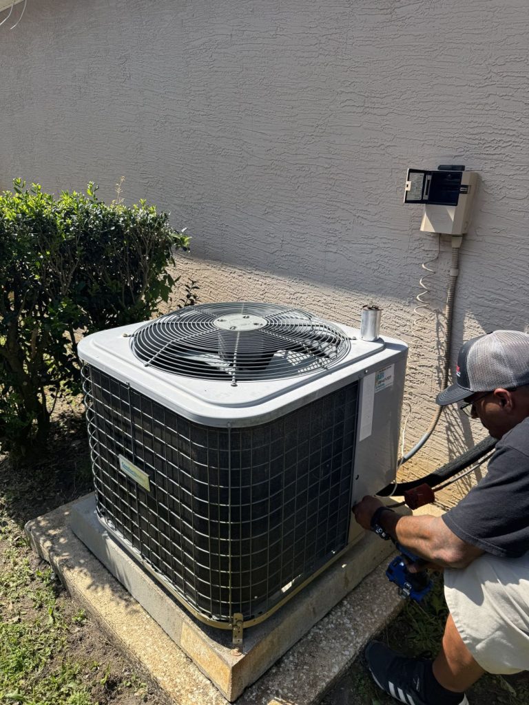 AC technician in Palm Coast installing a new AC unit outside of a customers home.